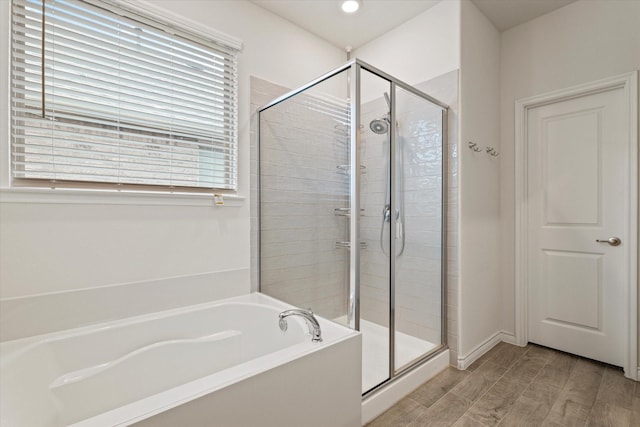 bathroom featuring separate shower and tub and a healthy amount of sunlight