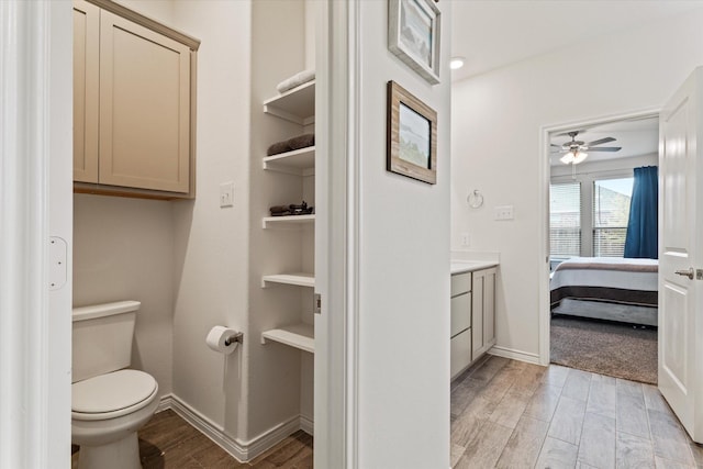 bathroom featuring vanity, toilet, and ceiling fan