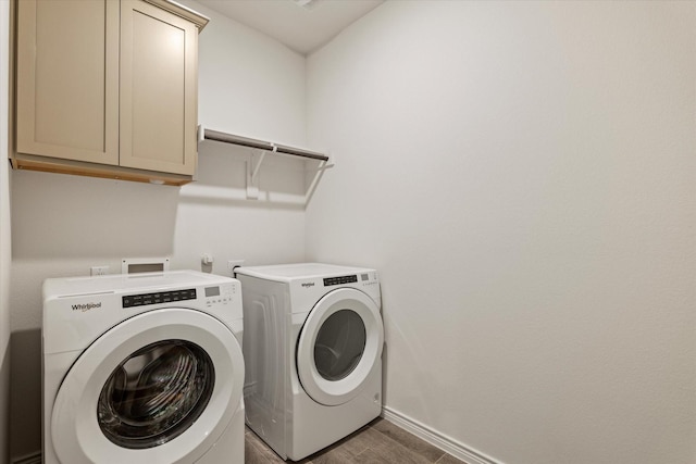 washroom with cabinets, dark hardwood / wood-style flooring, and washing machine and dryer