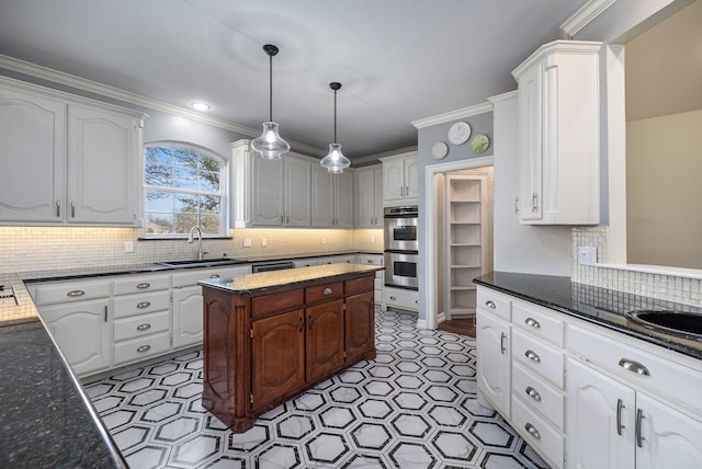 kitchen with white cabinetry, stainless steel double oven, sink, and hanging light fixtures