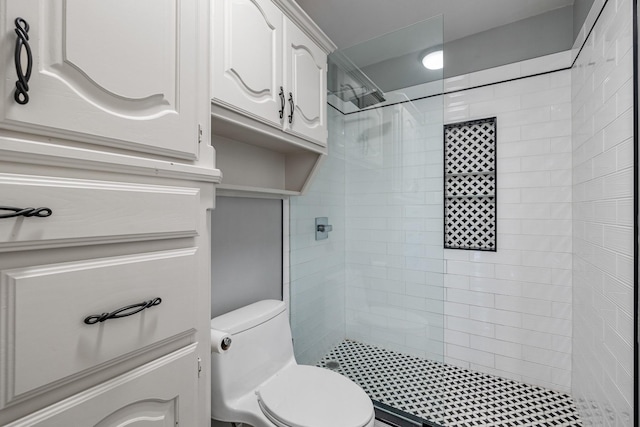 bathroom featuring toilet and a tile shower