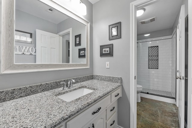 bathroom featuring vanity, toilet, and a tile shower