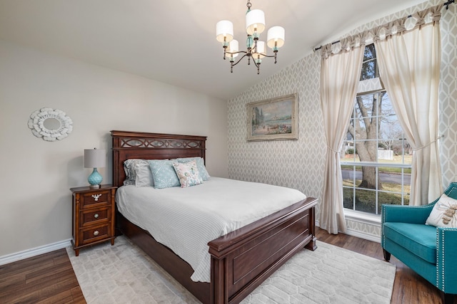 bedroom featuring hardwood / wood-style flooring, vaulted ceiling, and a notable chandelier