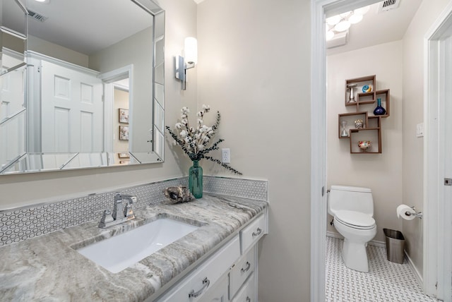 bathroom featuring vanity, tile patterned floors, and toilet