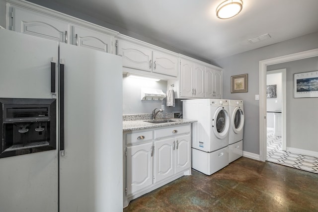 laundry area featuring sink, washing machine and dryer, and cabinets