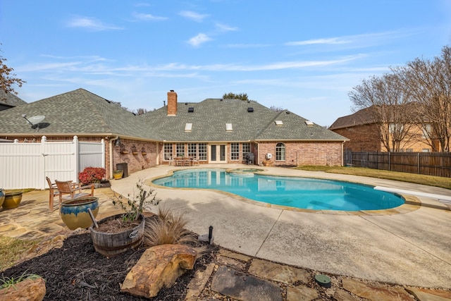 view of pool with a diving board, a patio, and an in ground hot tub