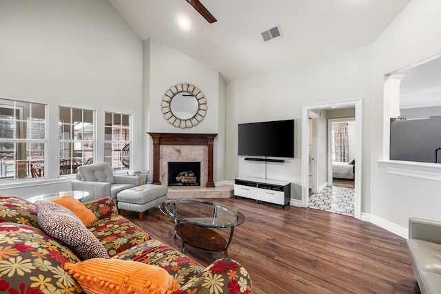 living room featuring a premium fireplace, high vaulted ceiling, dark wood-type flooring, and ceiling fan