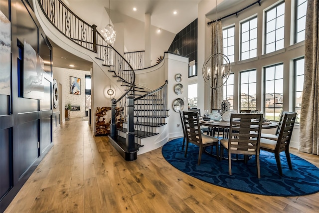 dining area featuring an inviting chandelier, hardwood / wood-style floors, and a high ceiling