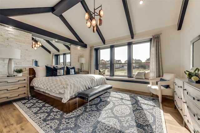 bedroom featuring vaulted ceiling with beams, light wood-type flooring, and an inviting chandelier