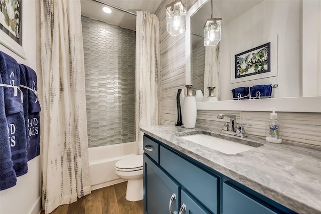 full bathroom featuring shower / tub combo with curtain, vanity, wood-type flooring, and toilet