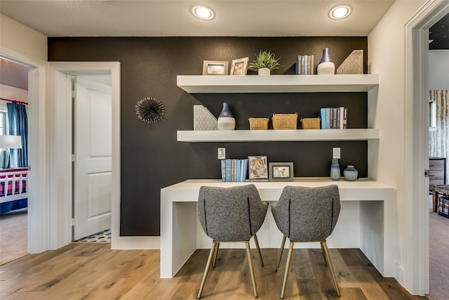 bar featuring built in desk, wood-type flooring, and built in features