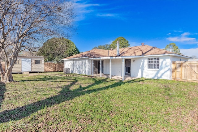 back of property featuring central AC, a shed, and a lawn