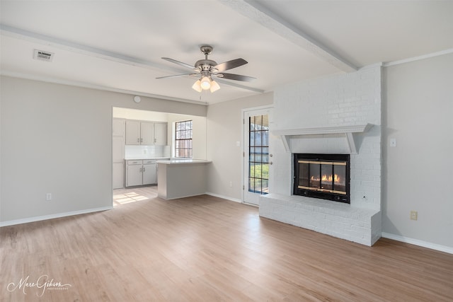 unfurnished living room with beamed ceiling, ceiling fan, light hardwood / wood-style floors, and a fireplace