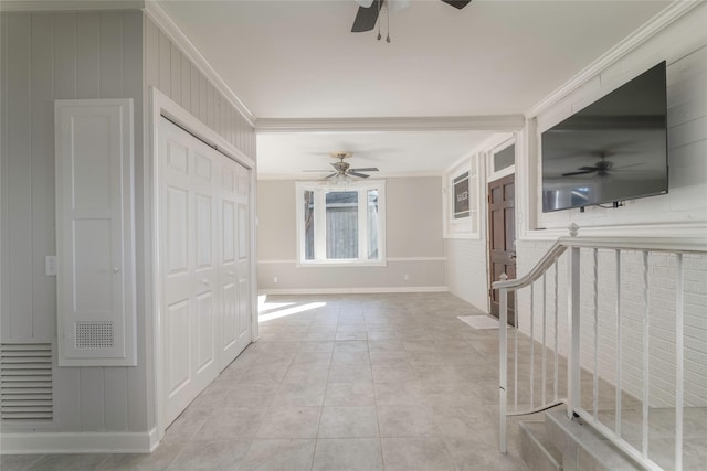 hallway with light tile patterned floors and crown molding