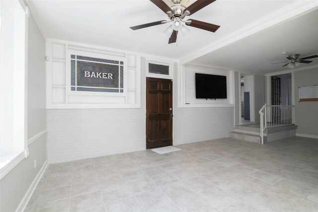 interior space featuring light tile patterned flooring, crown molding, ceiling fan, and built in shelves