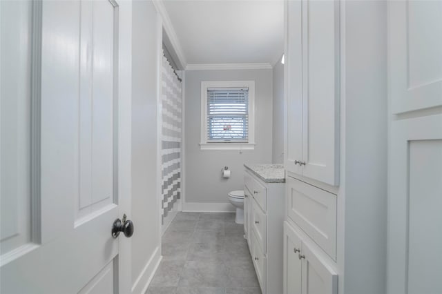 bathroom with crown molding, vanity, tile patterned floors, and toilet