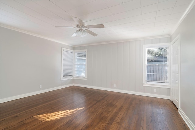 empty room featuring ceiling fan, ornamental molding, and dark wood-type flooring