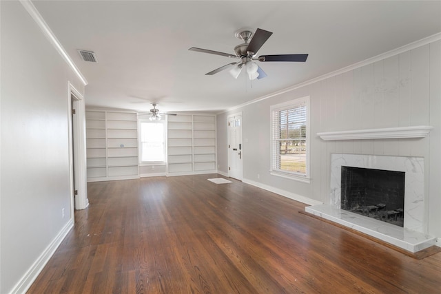 unfurnished living room with dark wood-type flooring, crown molding, built in features, ceiling fan, and a high end fireplace