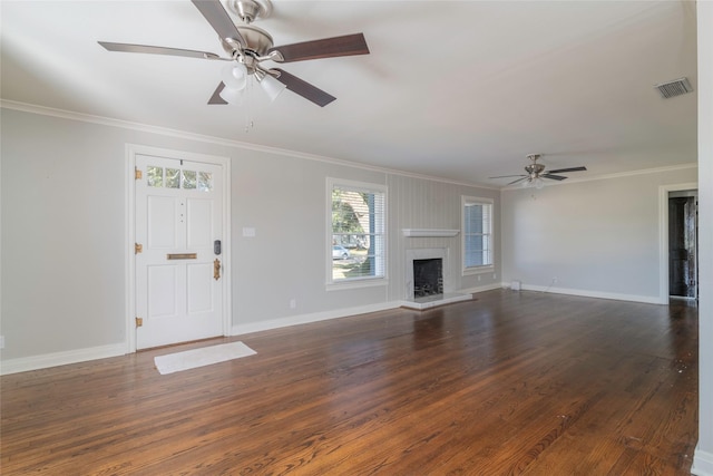 unfurnished living room featuring ceiling fan, crown molding, a fireplace, and dark wood-type flooring