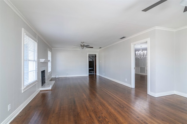 unfurnished living room with dark hardwood / wood-style flooring, a wealth of natural light, a large fireplace, and crown molding