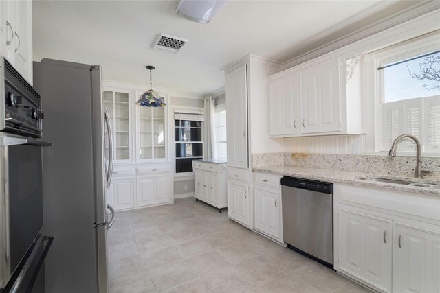 kitchen featuring decorative light fixtures, stainless steel appliances, white cabinetry, and sink