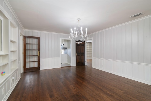 unfurnished dining area featuring crown molding, a chandelier, dark hardwood / wood-style flooring, and built in shelves