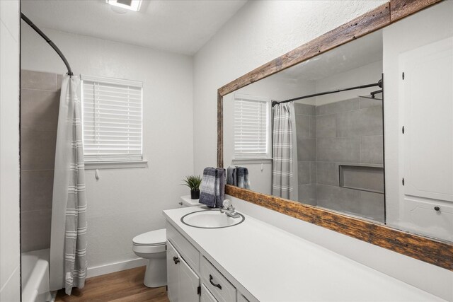 full bathroom featuring hardwood / wood-style floors, vanity, toilet, and shower / tub combo with curtain