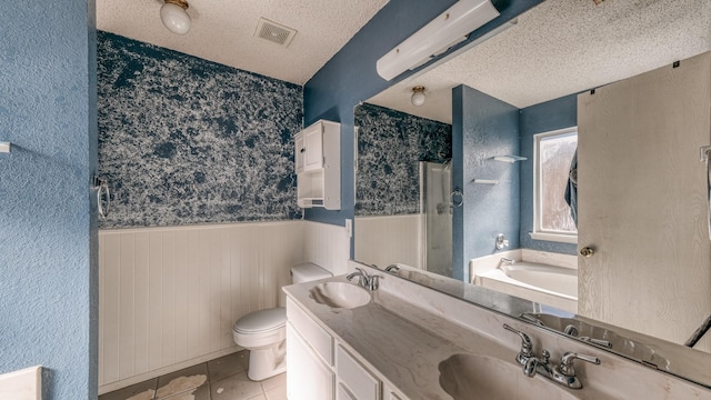 bathroom with toilet, a textured ceiling, vanity, tile patterned flooring, and a washtub