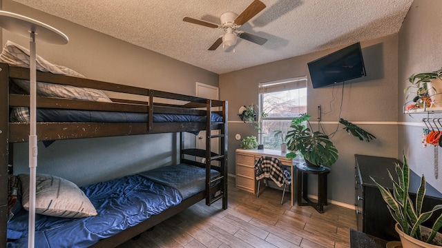 bedroom with hardwood / wood-style floors, a textured ceiling, and ceiling fan