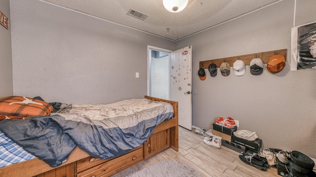 bedroom featuring a textured ceiling and light wood-type flooring