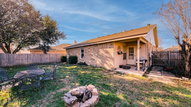 rear view of property featuring a yard and a patio area