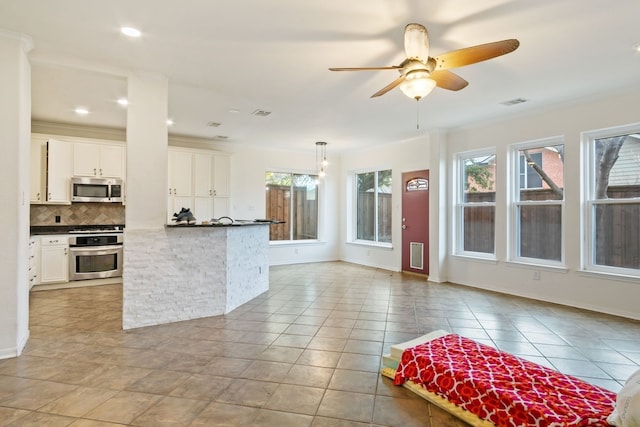 kitchen with backsplash, crown molding, white cabinets, and appliances with stainless steel finishes