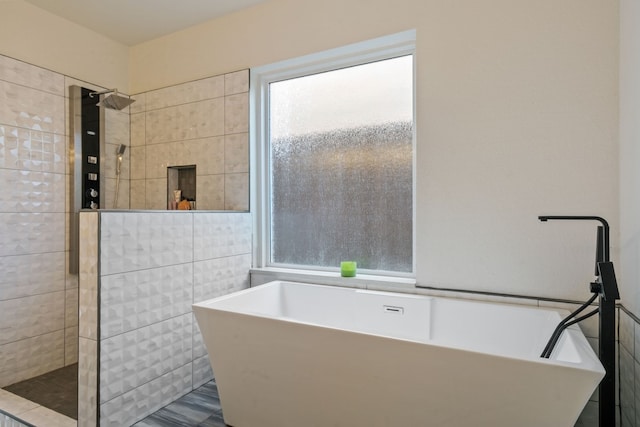 bathroom featuring hardwood / wood-style floors, tile walls, and plus walk in shower