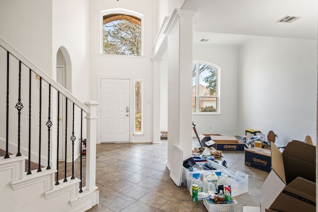 tiled entrance foyer featuring a wealth of natural light and a towering ceiling