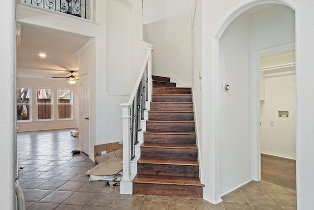 stairs with tile patterned floors, ceiling fan, and ornamental molding