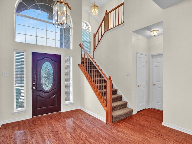 foyer with an inviting chandelier, a high ceiling, and hardwood / wood-style flooring