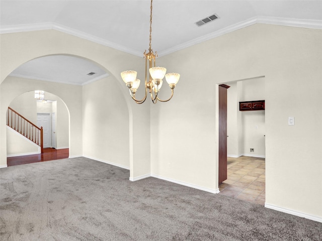 carpeted empty room featuring a notable chandelier, vaulted ceiling, and ornamental molding