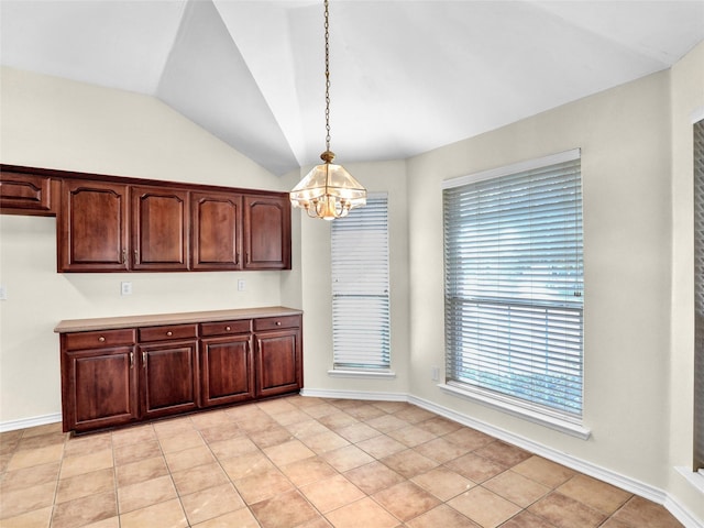 kitchen featuring light tile patterned floors, pendant lighting, lofted ceiling, and an inviting chandelier