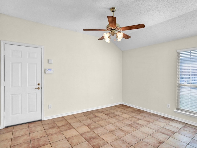 tiled empty room featuring a textured ceiling, vaulted ceiling, and ceiling fan