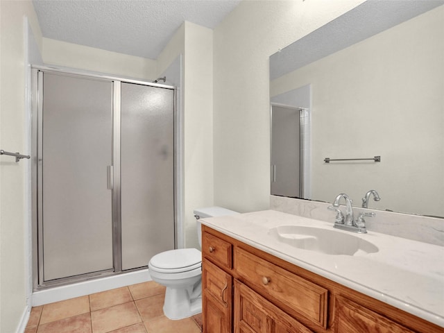 bathroom with tile patterned floors, a textured ceiling, toilet, a shower with door, and vanity