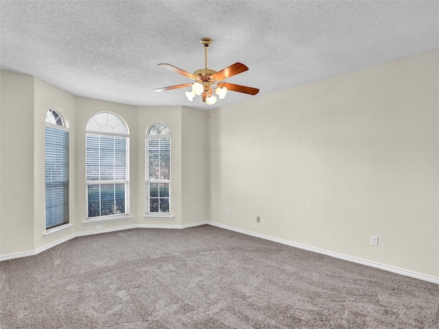 carpeted spare room with ceiling fan and a textured ceiling