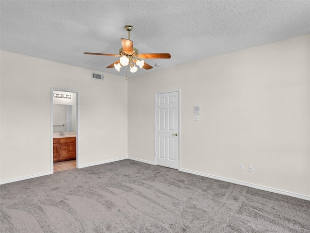 carpeted spare room with ceiling fan, sink, and a textured ceiling