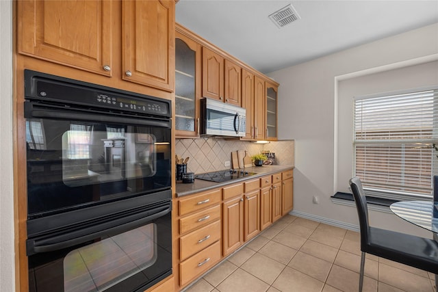 kitchen with backsplash, light tile patterned floors, and black appliances