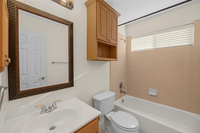 full bathroom featuring vanity, tiled shower / bath combo, and toilet