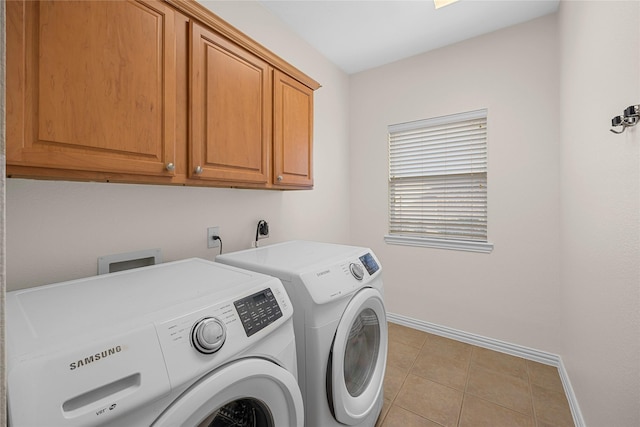 laundry area featuring cabinets, washer and dryer, and light tile patterned floors