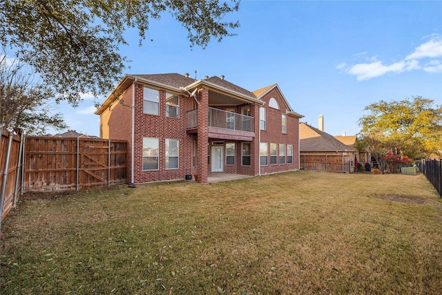 back of house featuring a patio, a balcony, and a yard