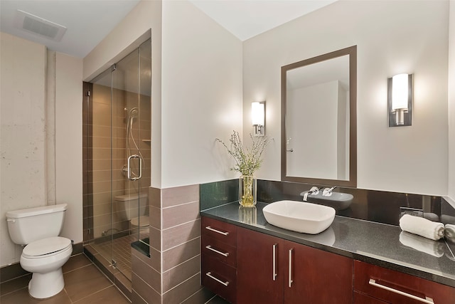 bathroom with tile patterned floors, toilet, an enclosed shower, and vanity