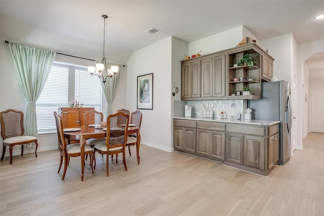 dining area with light wood-type flooring and a chandelier