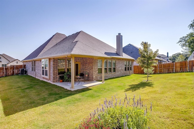 rear view of house with a yard, a patio, and cooling unit