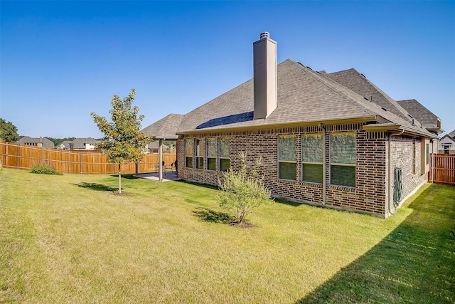 rear view of house with a patio area and a yard